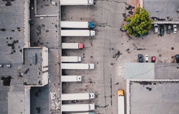 aerial view of trucks on gray commercial building during daytime